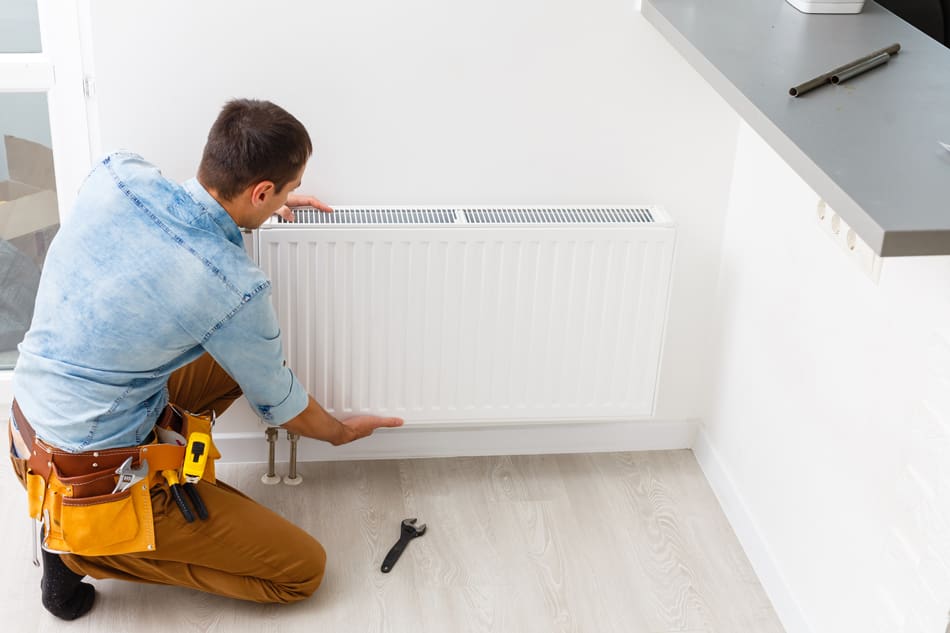 Repairman fixing a wall mounted A/C unit
